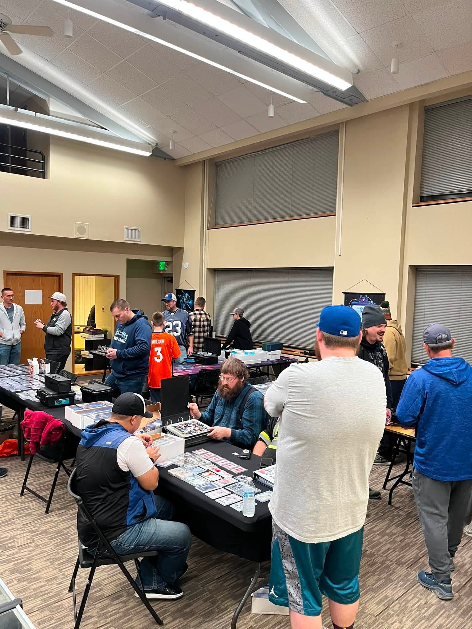 Sports-card collectors gathered around vendor tables